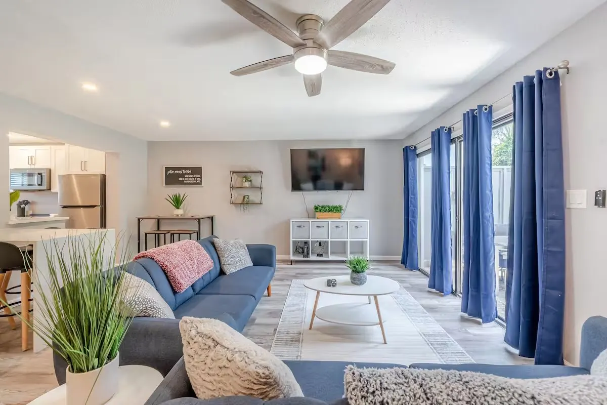Open living room with sectional sofa, kitchen and blue accents