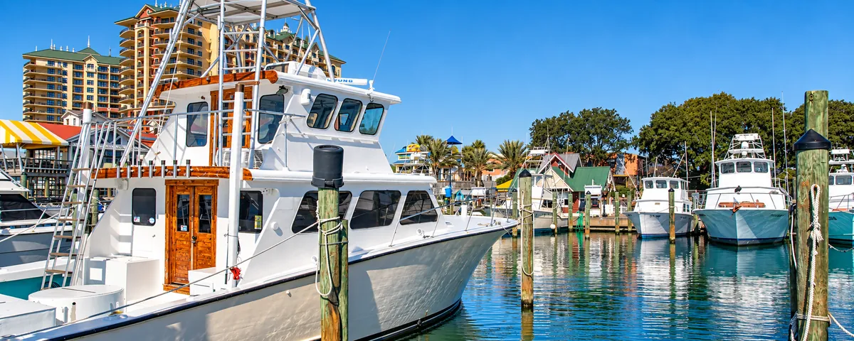 Sport fishing charter boats docked in Destin Harbor with a resort tower behind